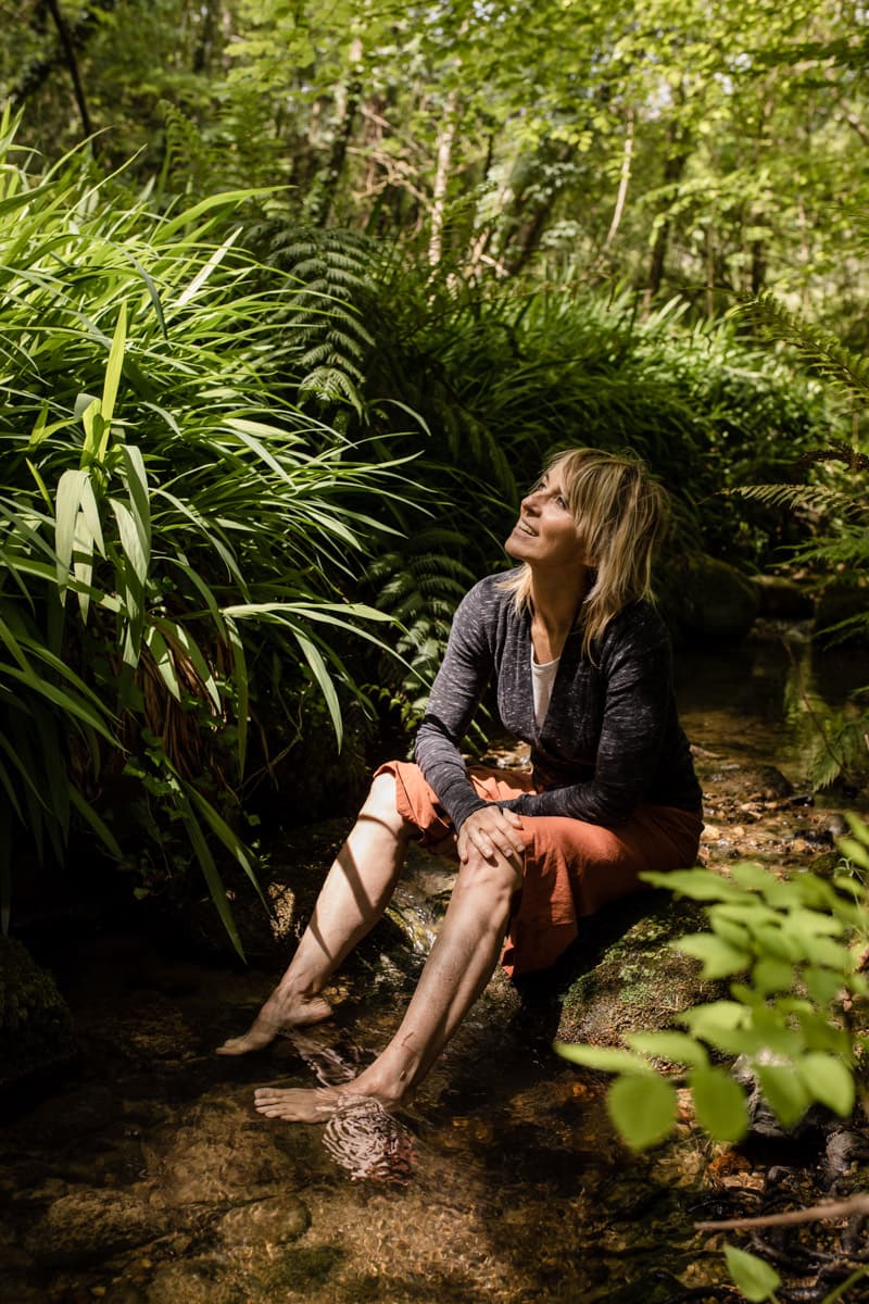ana urrutia profesora de yoga sentada en medio del bosque