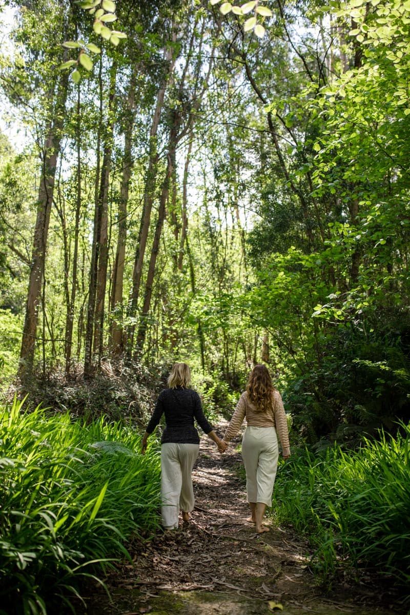 dos chcias caminando de la mano en la naturaleza