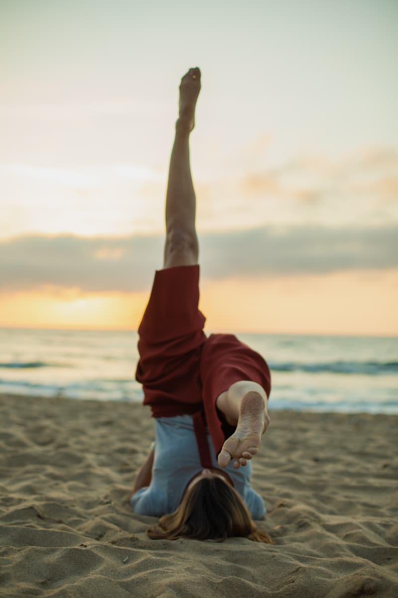 una persona practicando yoga en la playa