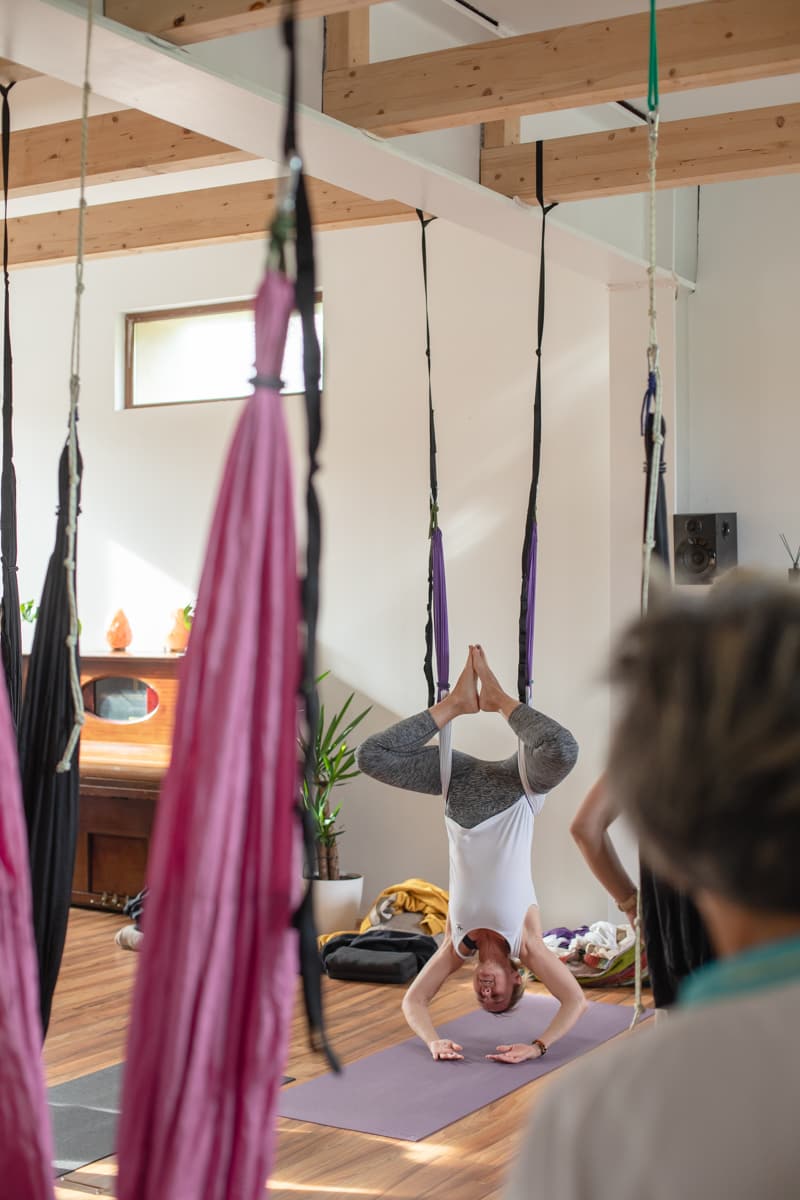 una profesora de yoga dando una clase de yoga aéreo